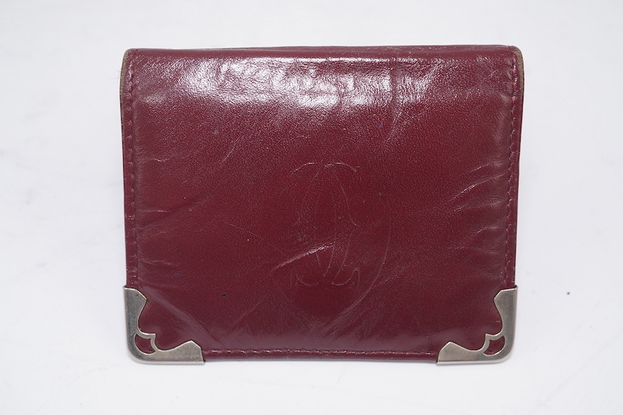 An assortment of Must de Cartier bordeaux leather accessories